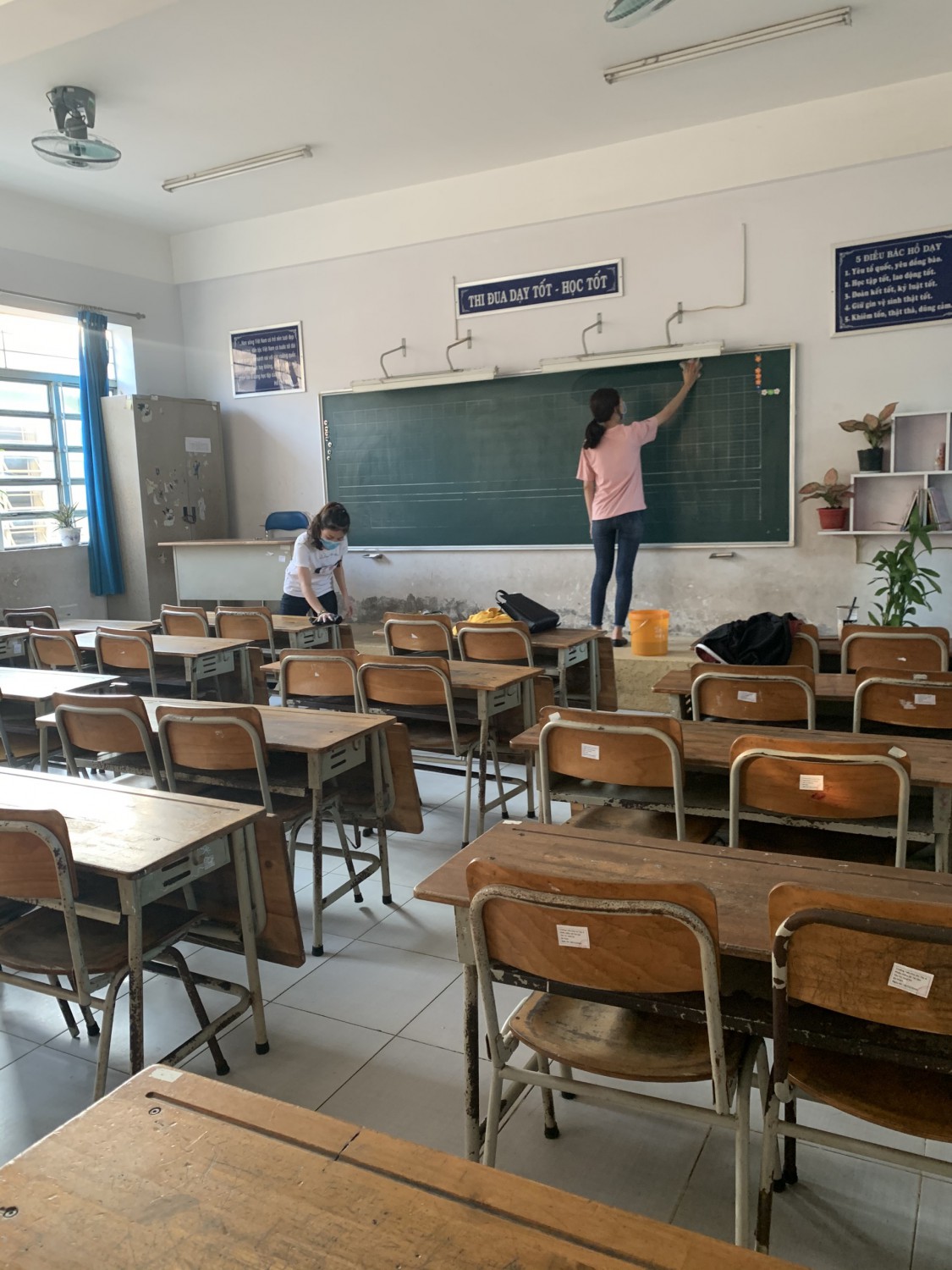 Giáo viên các lớp lau dọn bàn ghế, lớp học sau khi phun xịt thuốc khử trùng phòng tránh dịch bệnh covid-19